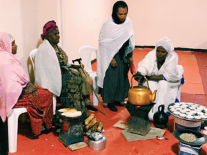 Women in Ethiopia making popcorn and coffee in a ceremony.