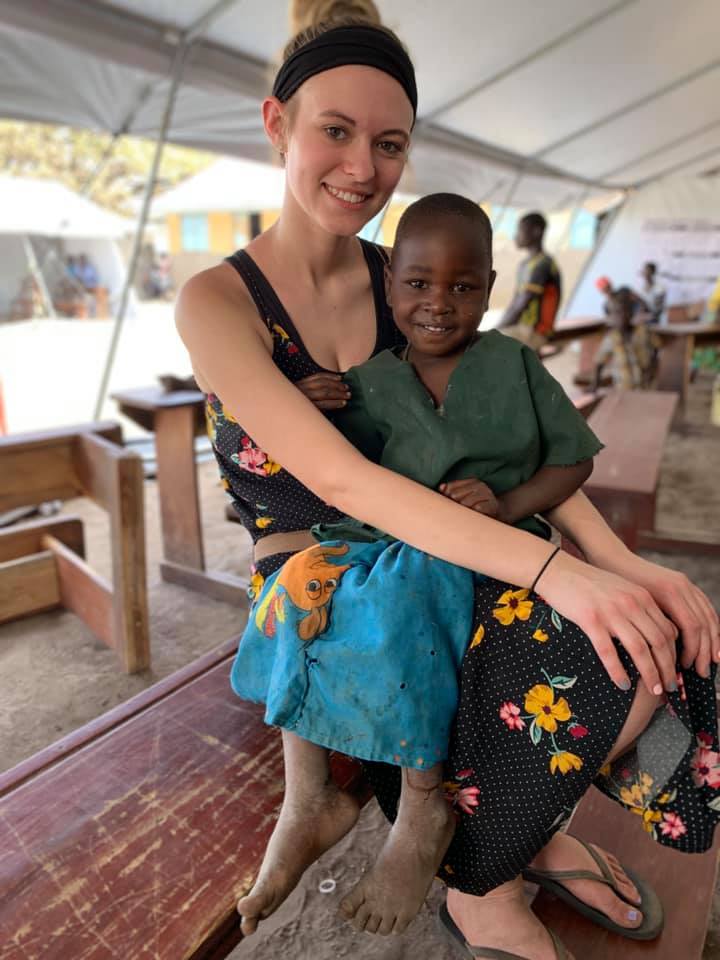Girl sits with child in Uganda while visiting