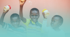 Children in Uganda holding peanut butter in the air