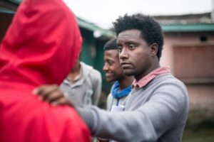 Ethiopian leader with his hand on the shoulder of someone in a red hoodie