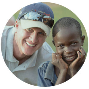 Rick posing next to a child in Africa.