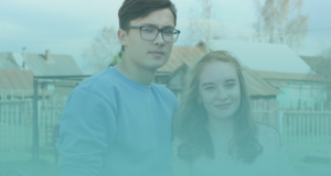 A boy with glasses and girl in Russia pose together