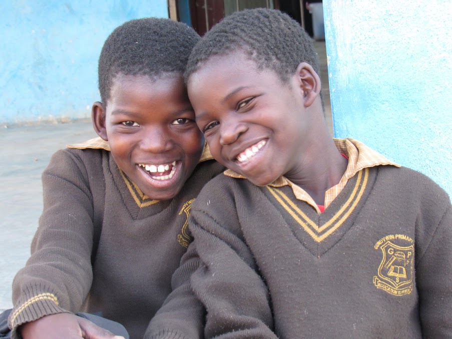 Two children in Eswatini smile while looking at the camera