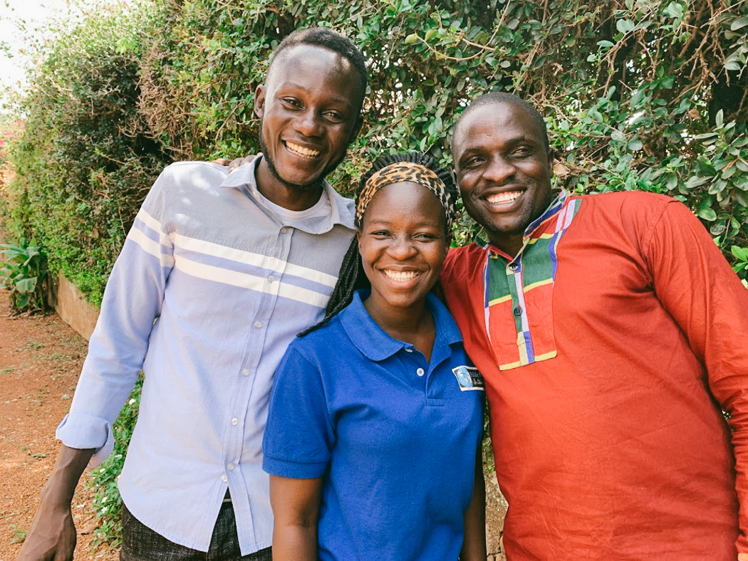 Three CarePoint Coordinators in Uganda stand together posing and smiling