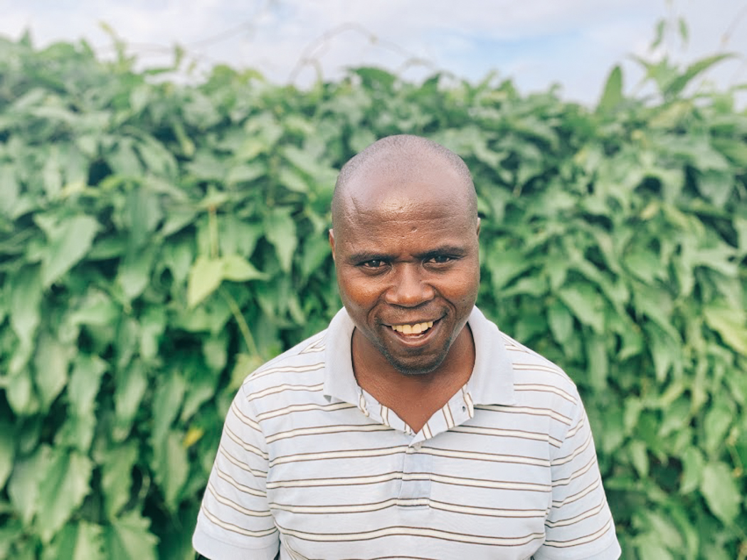 Portrait of Fred standing in front of a bush and smiling