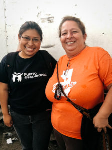 Jomora wearing an orange Guatemala shirt, smiling with Nelly.
