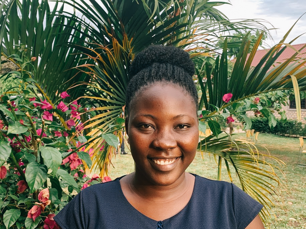 Josephine standing in front of a flowering plant, smiling