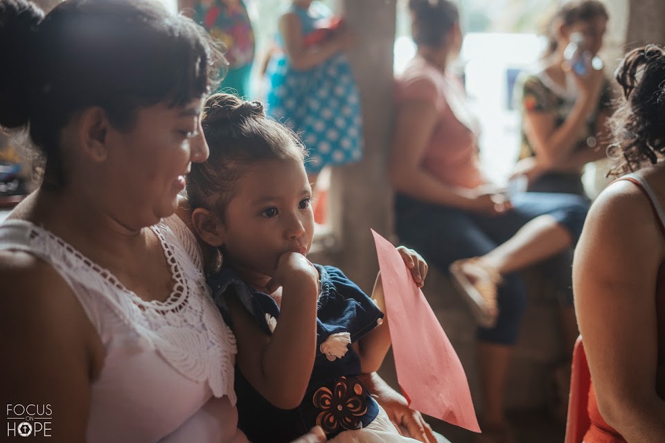 A mother smiles down at her young girl