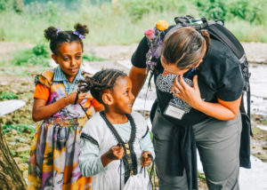 Whitney leaning down to speak to Hiwot, a young girl