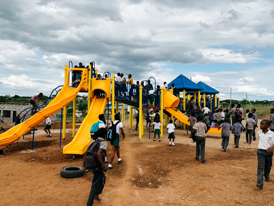 Lots of children climbing on new playground equipment