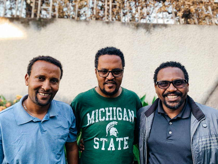 Fikre, Yared, and Alex smiling in a group