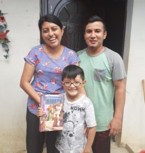 Family in Guatemala poses with Bible stories book