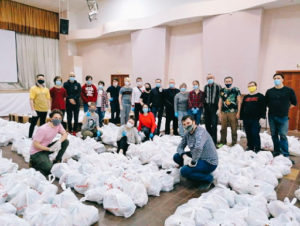 Volunteers standing next to care kits