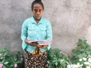 A girl in Ethiopia holding a stack of books