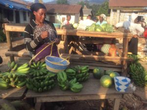 Resta at a marketplace table with fruits and fresh food