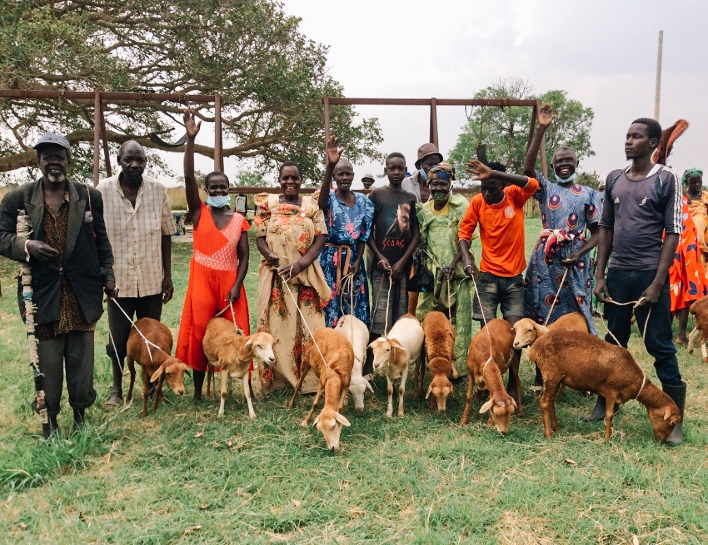 Ugandan community members with their new sheep
