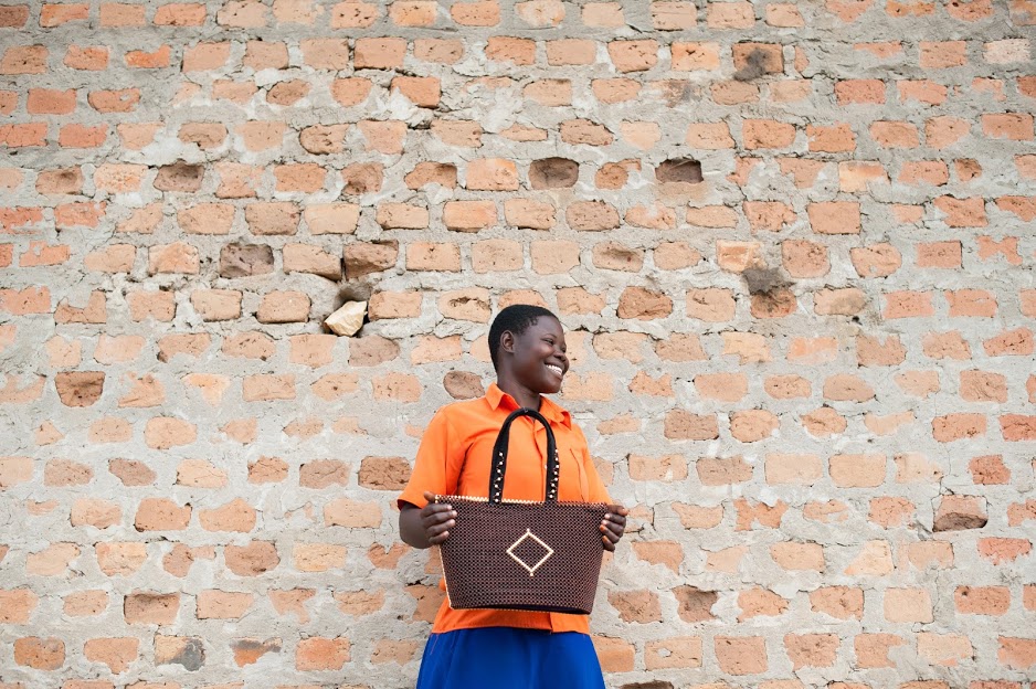 Woman in Uganda holding a handmade purse