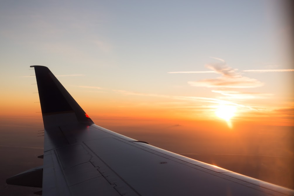 Airplane flying over sunset